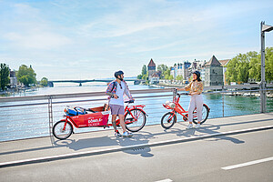 Symbolbild Lastenfahrrad und normales Fahrend mit Personen auf Brücke