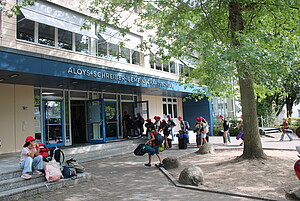 Kinder betreten eine Schulunterkunft.