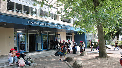 Kinder betreten eine Schulunterkunft.